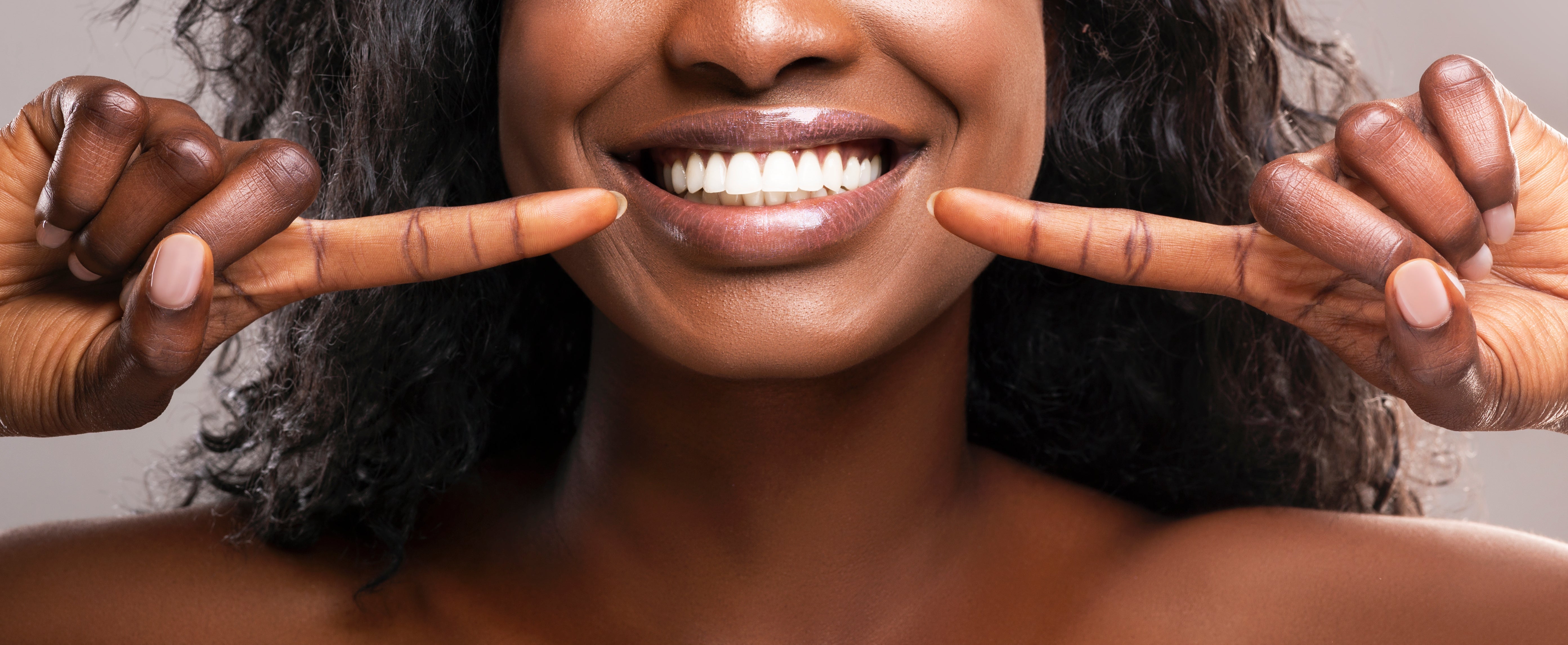 Woman Pointing to Smile with Healthy White Teeth by Prostock-studio
