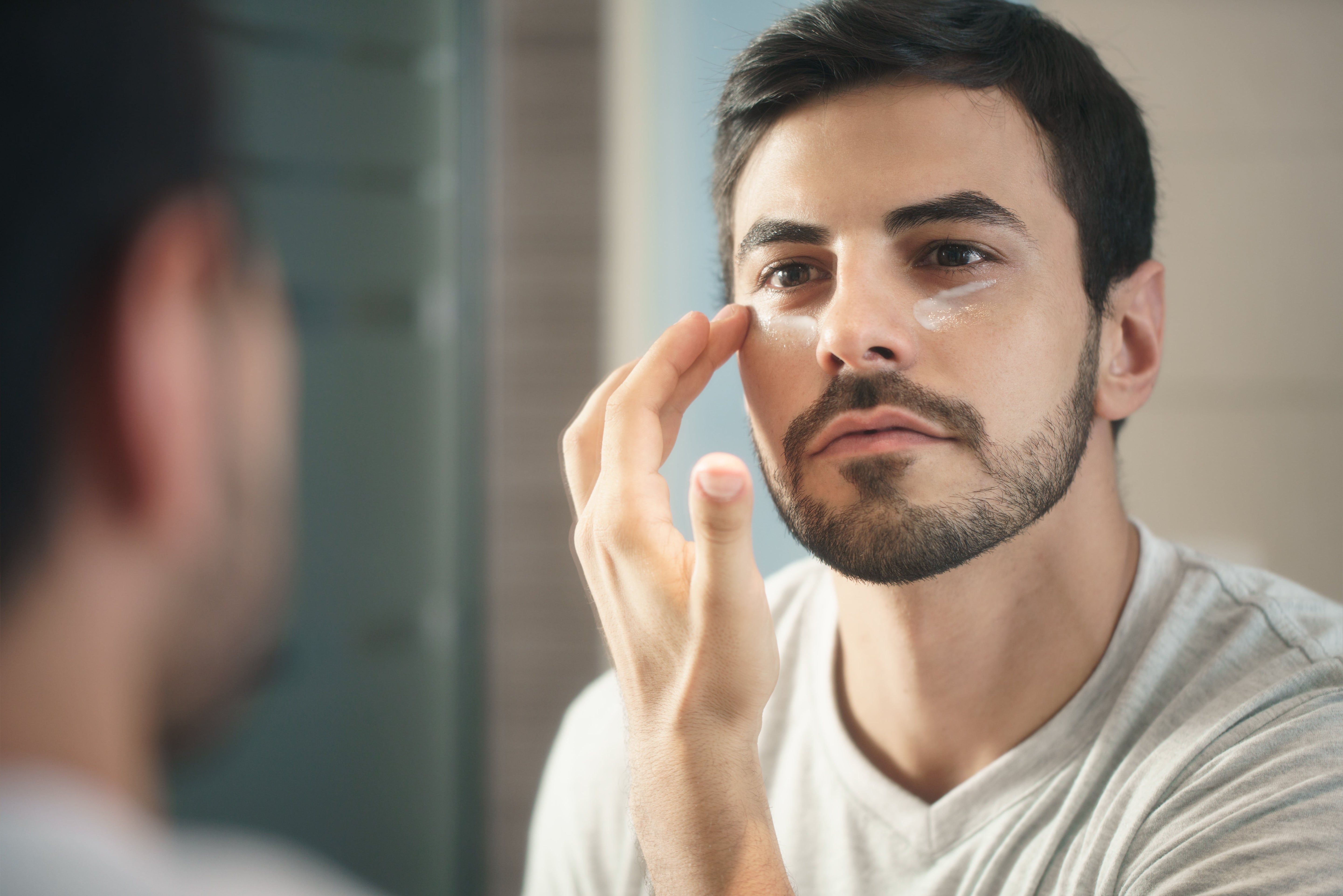Man applying anti-aging lotion for skin care by Diego Cervo via Adobe Stock.
